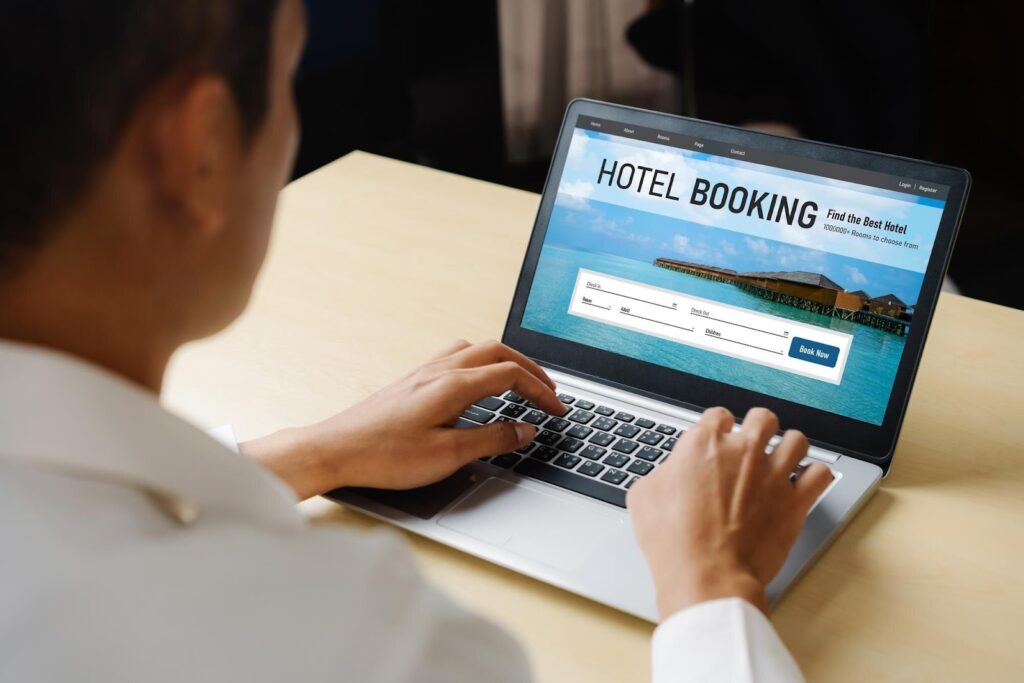 Person using a laptop to complete a hotel booking online, illustrating the importance of a smooth and frictionless booking engine experience
